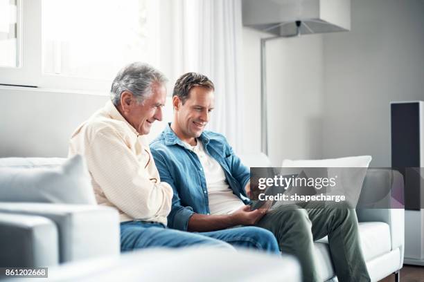 giving dad the gift of connectivity - old man son stock pictures, royalty-free photos & images