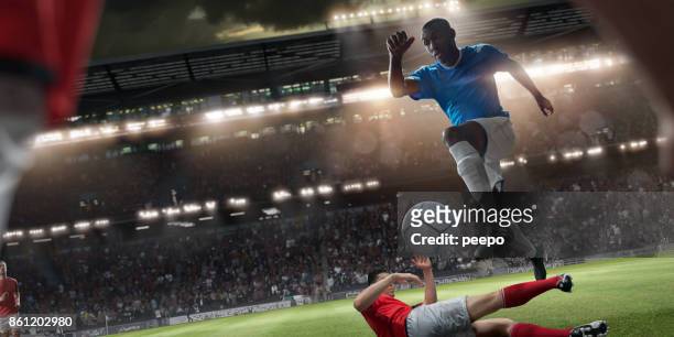 jugador profesional del fútbol, saltando por encima de jugadores rivales durante partido de fútbol - soccer striker fotografías e imágenes de stock