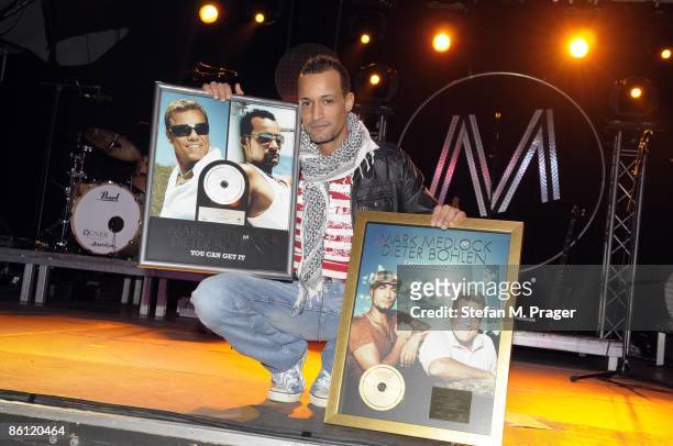 Photo of Mark MEDLOCK, posed with platinum record
