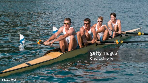 午後遅くにボート湖を渡って 4 つの男性選手 - sweep rowing ストックフォトと画像