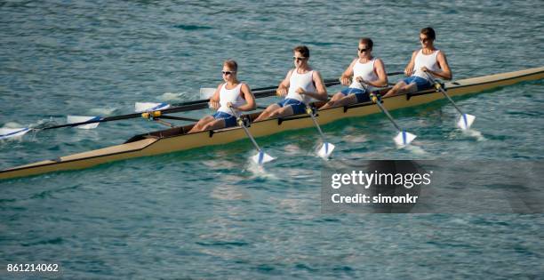 午後遅くにボート湖を渡って 4 つの男性選手 - sweep rowing ストックフォトと画像