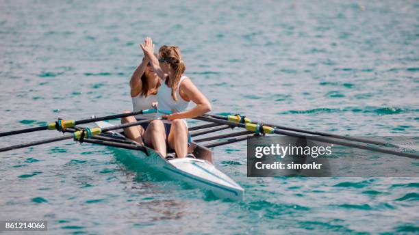 二重スカルにハイタッチをやって 2 つ女子ボート選手 - sweep rowing ストックフォトと画像