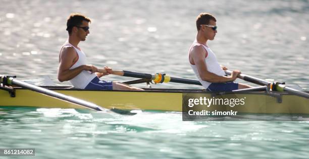 午後遅くにボート湖を渡って 2 つの男子選手 - sweep rowing ストックフォトと画像