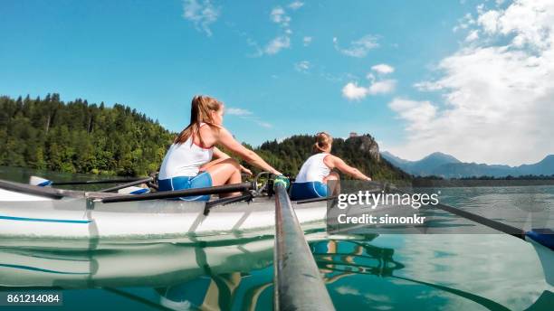 午後遅くに��ボート湖を渡って 2 つの女性アスリート - sweep rowing ストックフォトと画像