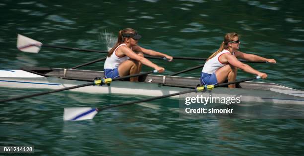 午後遅くにボート湖を渡��って 2 つの女性アスリート - sweep rowing ストックフォトと画像