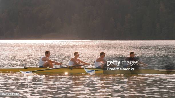 午後遅くにボート湖を渡って 4 つの男性選手 - sweep rowing ストックフォトと画像