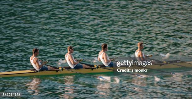 午後遅くにボート湖を渡って 4 つの男性選手 - sweep rowing ストックフォトと画像