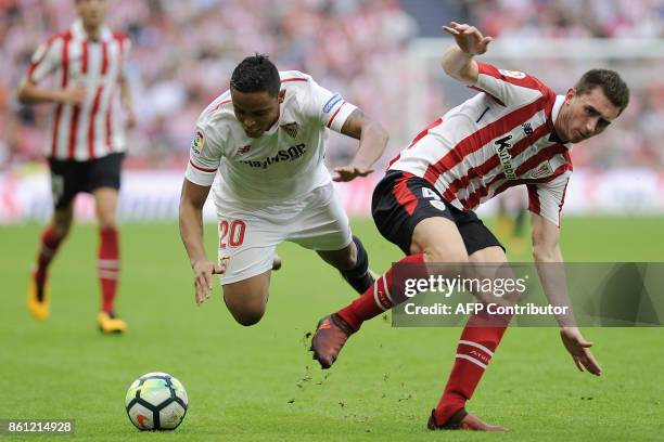 Sevilla's Colombian forward Luis Muriel challenges Athletic Bilbao's French defender Aymeric Laporte during the Spanish league football match...