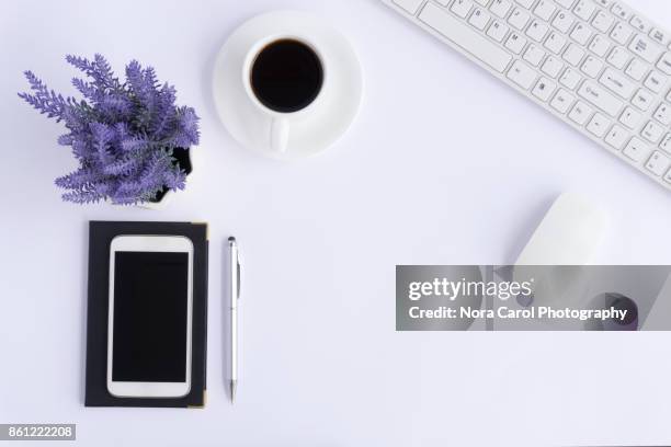 simple office desk with smart phone, coffee, pen, keyboard and flower on white - computer mouse table stock-fotos und bilder