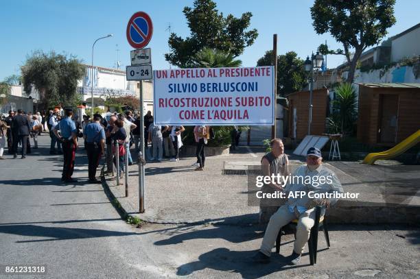 People wait for the arrival of Italian former Prime Minister and president of right-wing party Forza Italia, Silvio Berlusconi, on October 14, 2017...