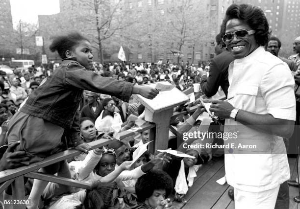 Photo of FANS and James BROWN; posed, signing autographs for fans, girl reaching with autograph book