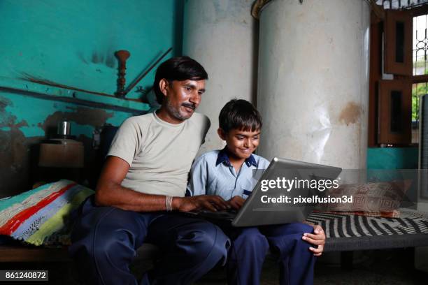 father & son using laptop at home - children india stock pictures, royalty-free photos & images