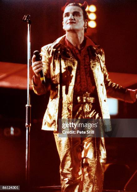 Photo of BONO and U2, Bono performing live onstage dressed as Mister Macphisto character, wearing devil horns, on the Zoo TV Zooropa tour