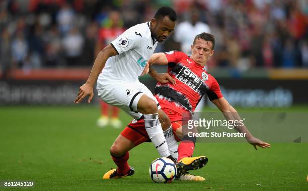 Town player Jonathan Hogg fouls Jordan Ayew of Swansea and receives a yellow card for it during the Premier League match between Swansea City and...