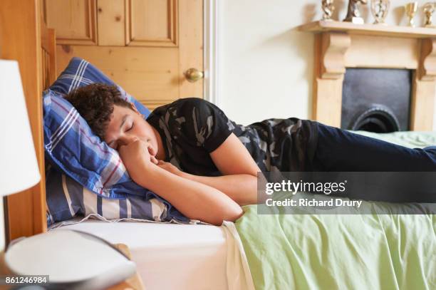 teenage boy sleeping on his bed - teen sleeping bedroom stock pictures, royalty-free photos & images