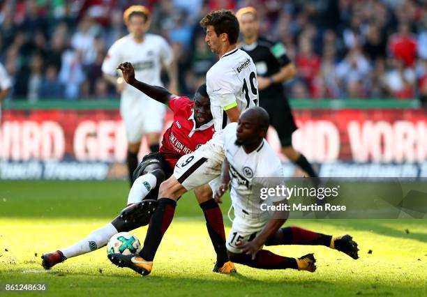 Ihlas Bebou of Hannover and David Abraham and Jetro Willems of Frankfurt battle for the ball during the Bundesliga match between Hannover 96 and...