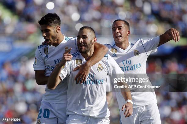 Real Madrid's French forward Karim Benzema celebrates with Real Madrid's Spanish midfielders Marco Asensio and Lucas Vazquez after scoring a goal...