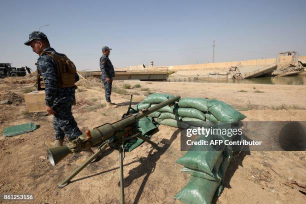 Iraqi forces stand on a river bank across from Kurdish peshmerga positions on October 14 on the southern outskirts of Kirkuk. Thousands of Iraqi...