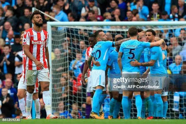 Stoke City's German midfielder Eric Maxim Choupo-Moting reacts as Manchester City players celebrate their sixth goal during the English Premier...