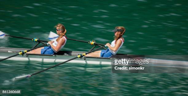 午後遅くにボート湖を渡って 2 つの女性アスリート - sweep rowing ストックフォトと画像