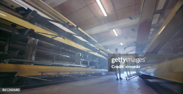 deux athlètes masculins prenant balayage rame bateau de hangars à bateaux - sweep rowing photos et images de collection