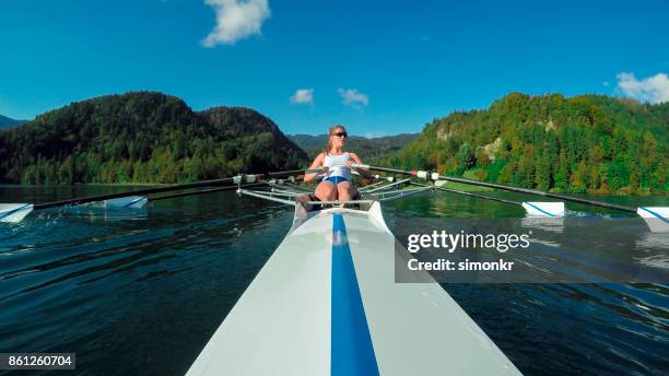 vrouwelijke atleet sculling op lake - single scull stockfoto's en -beelden