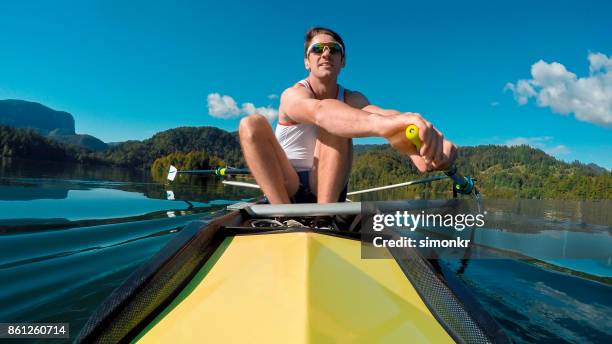 male athlete in yellow coxless pair rowing in sunshine - sweep rowing stock pictures, royalty-free photos & images