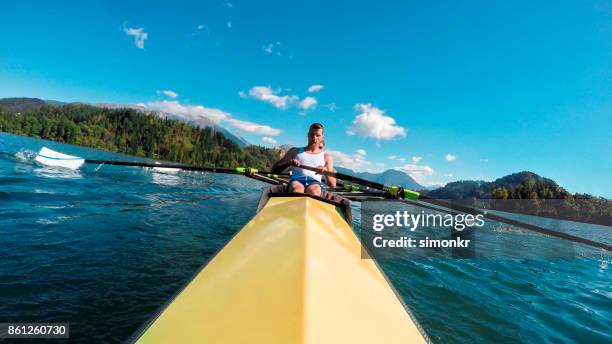 due atleti maschi in coppia giallo coxless canottaggio sotto il sole - sweep rowing foto e immagini stock