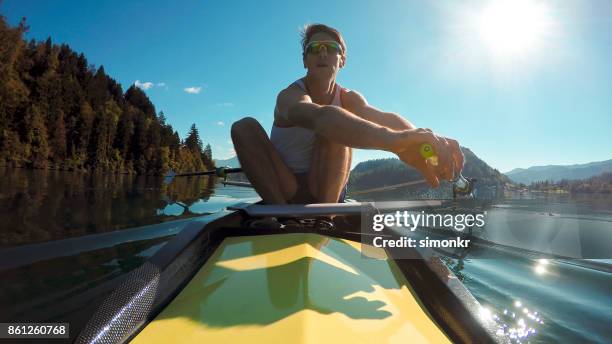 atleta maschio in coppia giallo coxless canottaggio sotto il sole - sweep rowing foto e immagini stock