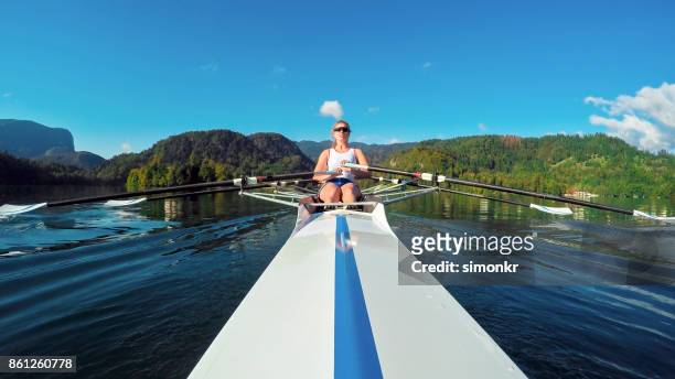 atleta donna che sculling sul lago - sweep rowing foto e immagini stock