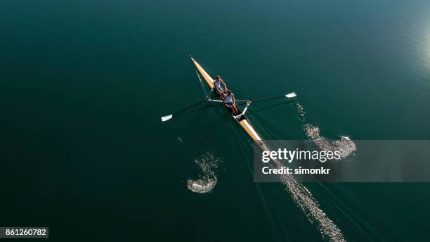 two male athletes sculling on lake in sunshine - sweep rowing stock pictures, royalty-free photos & images