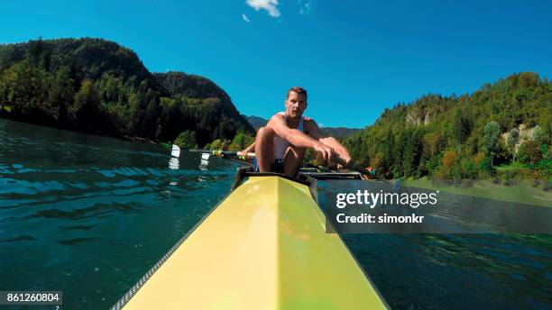 male athlete in yellow coxless pair rowing in sunshine - sweep rowing stock pictures, royalty-free photos & images