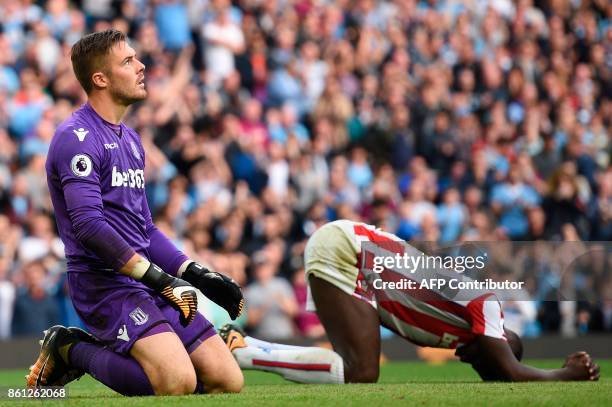 Stoke City's English goalkeeper Jack Butland and Stoke City's French defender Kurt Zouma react after Manchester City score their seventh goal during...