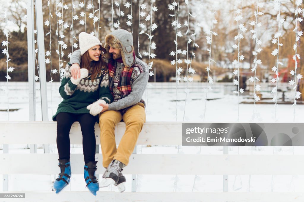 Joven pareja de enamorados disfruta día de invierno patinaje