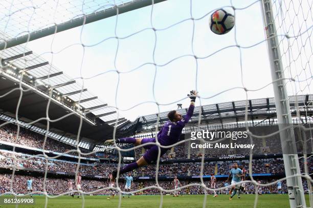Fernandinho of Manchester City scores his sides fifth goal as Jack Butland of Stoke City attempts to stop it during the Premier League match between...