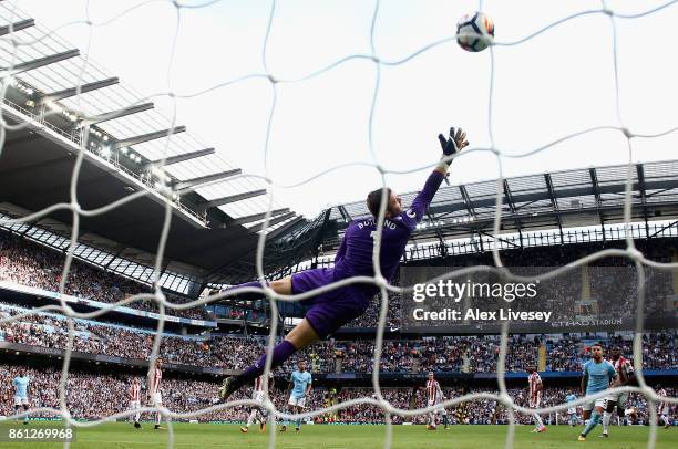 Fernandinho of Manchester City scores his sides fifth goal as Jack Butland of Stoke City attempts to stop it during the Premier League match between...