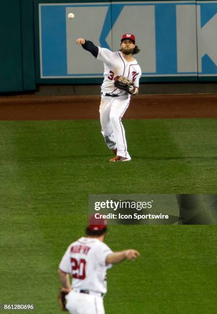 Washington Nationals second baseman Daniel Murphy directs right fielder Bryce Harper to throw to home plate during game five of the NLDS between the...
