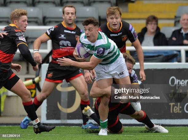 Adam Radwan of Newcastle Falcons is tackled by Pat Howard of Dragons in the second half during the European Rugby Challenge Cup match between...