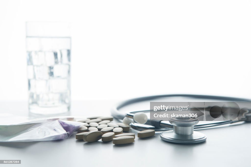 Working space of Doctor with stethoscope with medicine tablet and notebook for consult patient