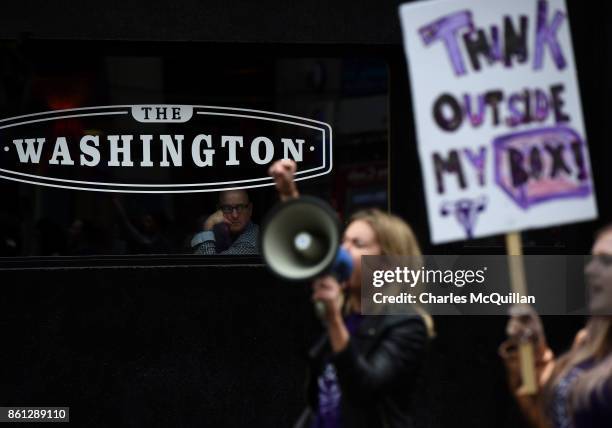 Man watches on from a bar window seat as protestors take part in the Rally for Choice march on October 14, 2017 in Belfast, Northern Ireland. The pro...