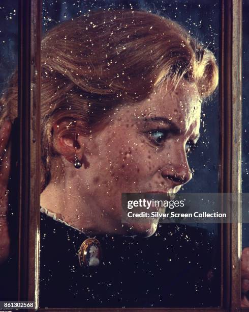 View of Scottish actress Deborah Kerr behind a rain-splattered window in a scene from 'The Innocents' , England, 1961.
