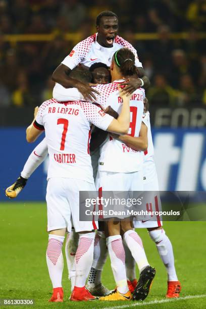 Jean-Kevin Augustin of RB Leipzig celebrates scoring his teams third goal of the game with team mates during the Bundesliga match between Borussia...