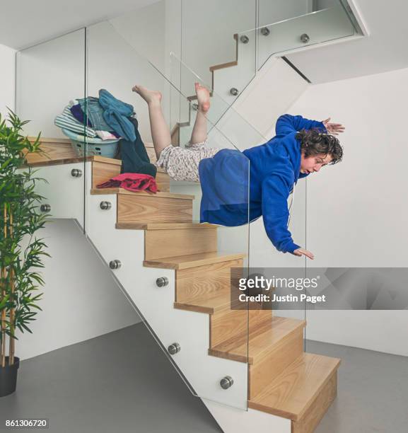 tripping over a pile of clothes on the stairs - accidents and disasters stock-fotos und bilder