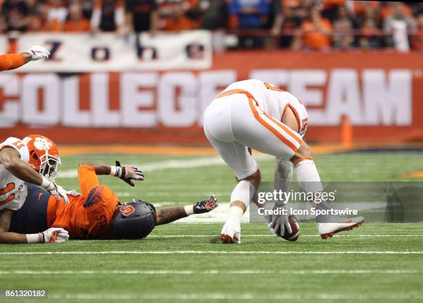 Syracuse Orange running back Dontae Strickland lays on the field after fumbling the football. Clemson Tigers safety Tanner Muse picks up the ball and...