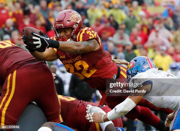 Running back David Montgomery of the Iowa State Cyclones dives into the end zone for a touchdown as safety Bryce Torneden of the Kansas Jayhawks...