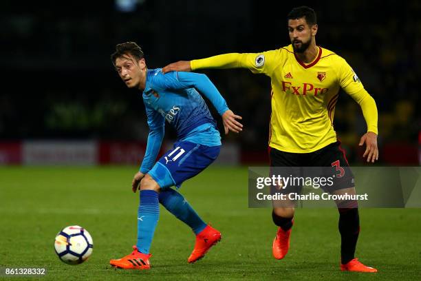 Arsenal's Mesut Ozil looks to hold the ball up from Watford's Miguel Britos during the Premier League match between Watford and Arsenal at Vicarage...