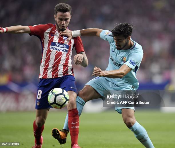 Atletico Madrid's Spanish midfielder Saul Niguez vies with Barcelona's Portuguese midfielder Andre Gomes during the Spanish league football match...