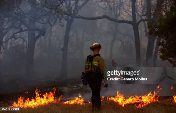 Firefighter with the Marin County Fire Department works a backfire in the Oakmont community along Highway 12 in Santa Rosa on October 13, 2017.