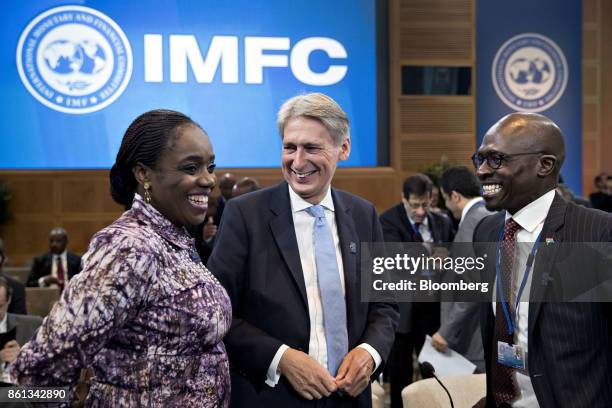 Philip Hammond, U.K. Chancellor of the exchequer, center, and Malusi Gigaba, South Africa's finance minister, right, speak with an attendee during an...