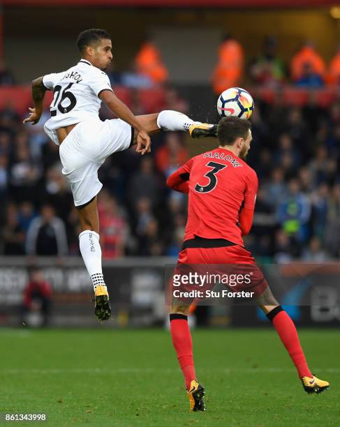 Swansea player Kyle Naughton challenges Scott Malone of Town to the ball during the Premier League match between Swansea City and Huddersfield Town...